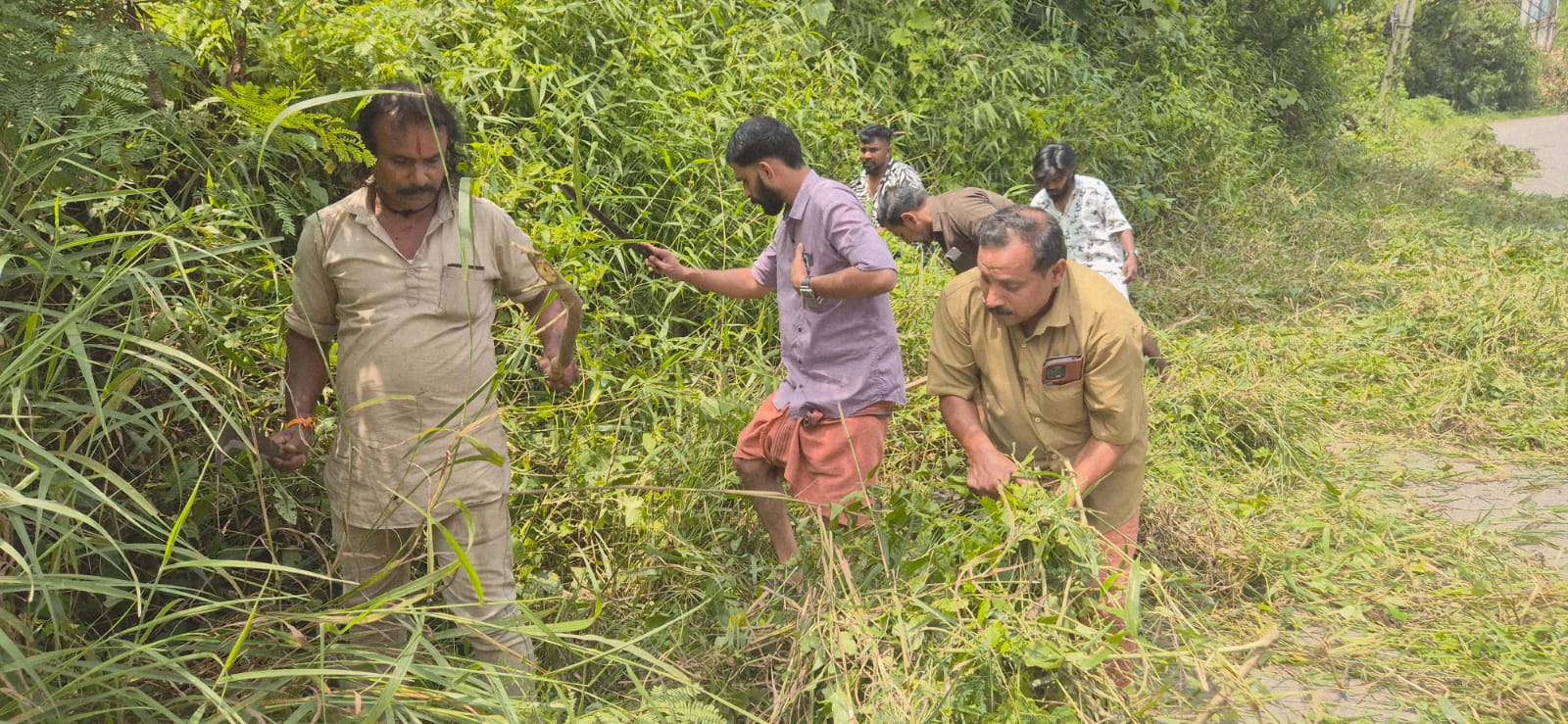 അപകടഭീഷണി ഉയർത്തിയ കാട് വെട്ടിത്തെളിച്ച് ബിജെപി കണിയാരം ബൂത്ത് കമ്മിറ്റി